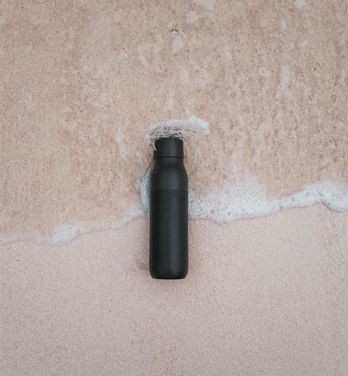 reusable water bottle on the beach